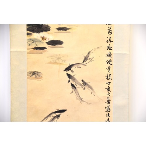 249 - A Chinese scroll depicting fish in a pond with lily pads, with Chinese character marks and two red s... 