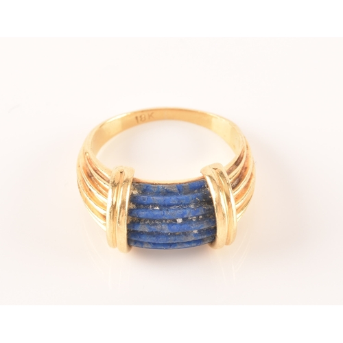 94 - An unusual Greek style yellow gold and lapis lazuli ring, set with ribbed lapis stone, with shaped r... 