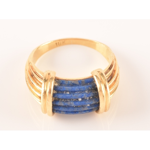 94 - An unusual Greek style yellow gold and lapis lazuli ring, set with ribbed lapis stone, with shaped r... 