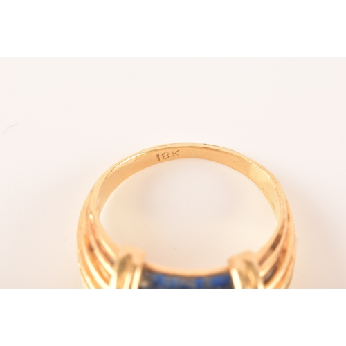 94 - An unusual Greek style yellow gold and lapis lazuli ring, set with ribbed lapis stone, with shaped r... 