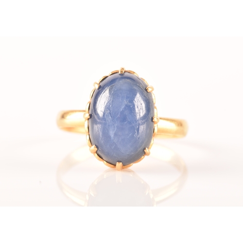 91 - A yellow metal and cabochon sapphire ring, set with an oval cabochon sapphire (showing mild asterism... 