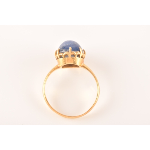 91 - A yellow metal and cabochon sapphire ring, set with an oval cabochon sapphire (showing mild asterism... 