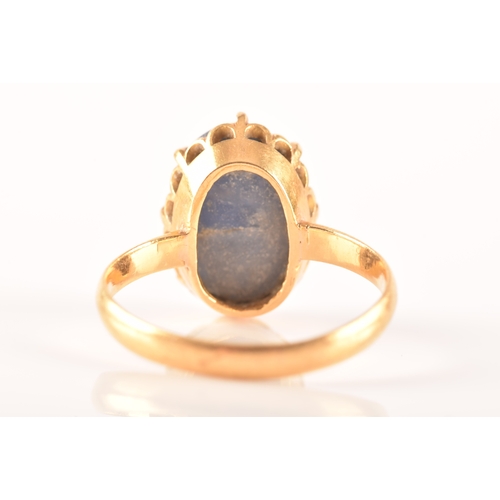 91 - A yellow metal and cabochon sapphire ring, set with an oval cabochon sapphire (showing mild asterism... 