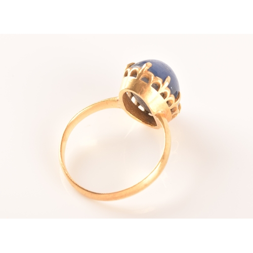 91 - A yellow metal and cabochon sapphire ring, set with an oval cabochon sapphire (showing mild asterism... 