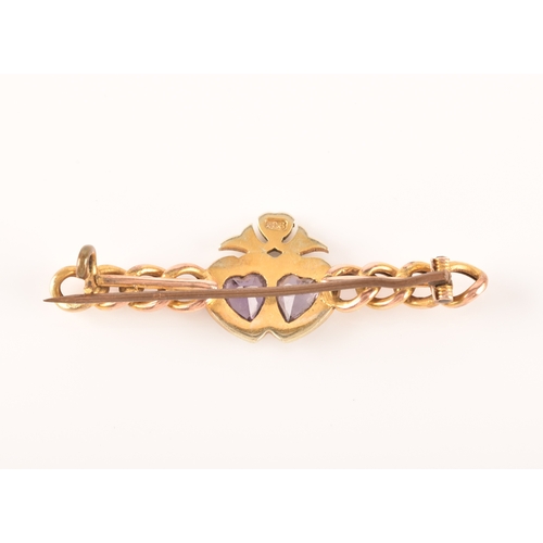 20 - A 9ct yellow gold and amethyst brooch, in a Celtic style, set with a large round-cut pale lilac amet... 