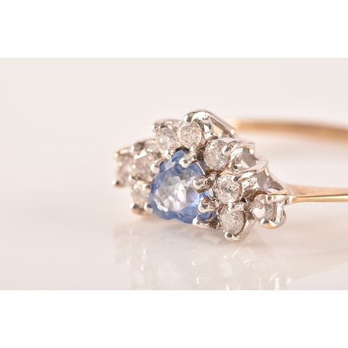 22 - A 9ct yellow gold, diamond, and sapphire ring, set with a mixed heart-cut sapphire, surrounded with ... 