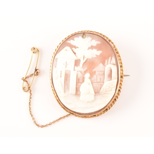 68 - A yellow metal mounted cameo brooch, the cameo depicting a woman in a long dress standing in a rural... 