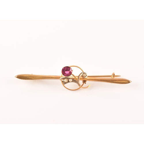 69 - A yellow metal and red stone clover bar brooch, set with two stones, unmarked, 1.7 cm long, together... 