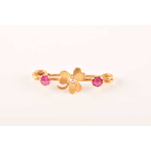 69 - A yellow metal and red stone clover bar brooch, set with two stones, unmarked, 1.7 cm long, together... 