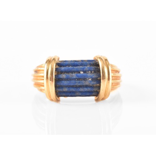 94 - An unusual Greek style yellow gold and lapis lazuli ring, set with ribbed lapis stone, with shaped r... 