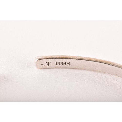 95 - Theo Fennell. A 18ct white and yellow gold  bangle set with a round brilliant cut yellow sapphire wi... 