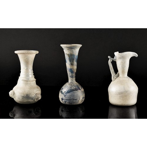 262 - Ca 1st-3rd century AD. A group of of three Ancient Roman blown glass unguentaria bottles, one with a... 