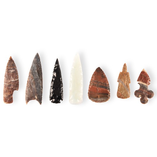 299 - A collection of seven spear heads of varying materials and colours, glass and stone carved and chipp... 