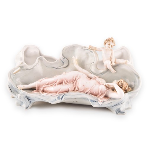 263 - A 19th century German porcelain figural group bowl, depicting a reclining woman and cherub, numbered... 