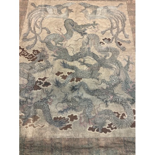 19 - A large antique Chinese silk needlework tapestry wall hanging, decorated with give dragons chasing a... 