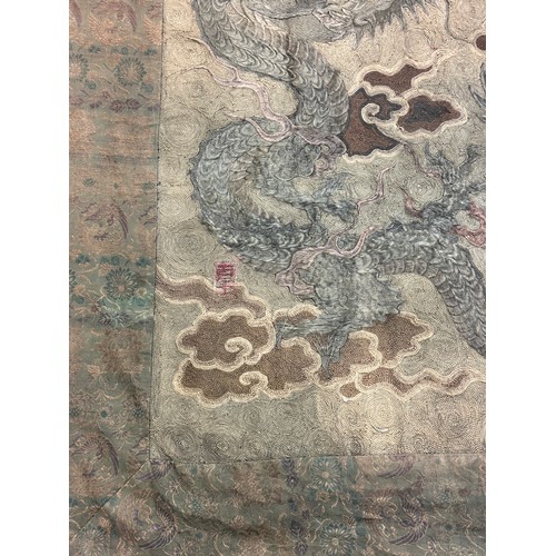 19 - A large antique Chinese silk needlework tapestry wall hanging, decorated with give dragons chasing a... 