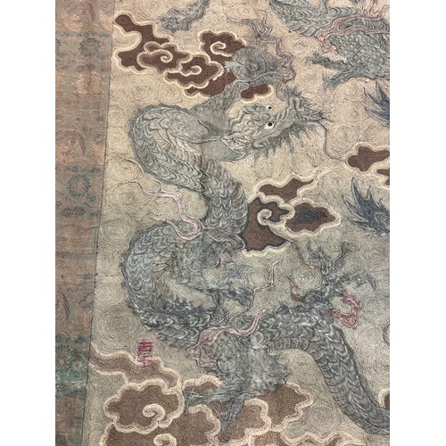 19 - A large antique Chinese silk needlework tapestry wall hanging, decorated with give dragons chasing a... 