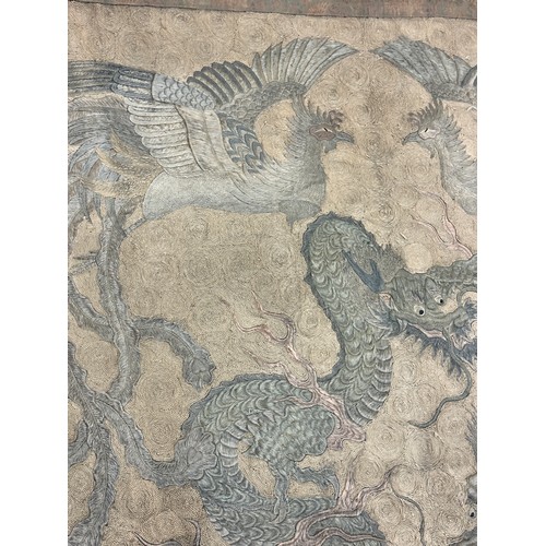 19 - A large antique Chinese silk needlework tapestry wall hanging, decorated with give dragons chasing a... 