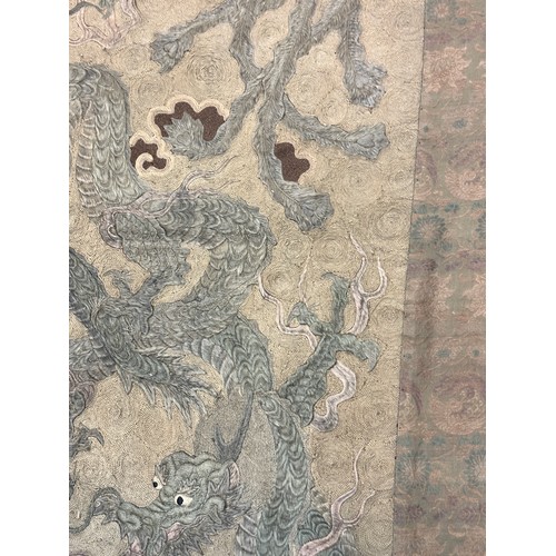 19 - A large antique Chinese silk needlework tapestry wall hanging, decorated with give dragons chasing a... 