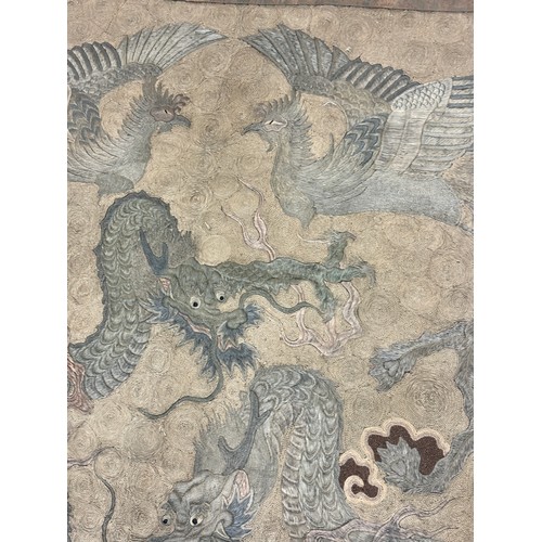 19 - A large antique Chinese silk needlework tapestry wall hanging, decorated with give dragons chasing a... 