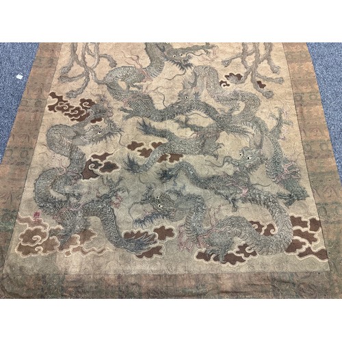 19 - A large antique Chinese silk needlework tapestry wall hanging, decorated with give dragons chasing a... 