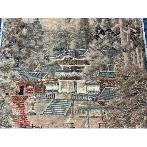 28 - A large Japanese antique silkwork depicting a Japanese town scene with traditional buildings, a red ... 