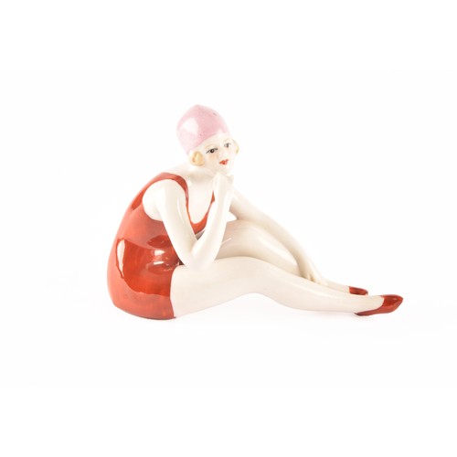 264 - A German Art Deco porcelain figurine of a bathing beauty, 12 x 9 cm, along with a small Japanese dis... 