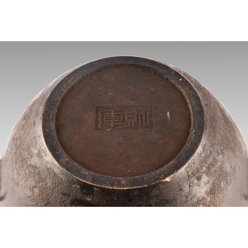 37 - An 18th century Chinese bronze bowl, with a rolled rim, dogs of foe handles, impressed Chinese chara... 