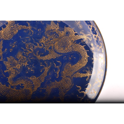 13 - A Chinese Qing Dynasty blue glaze and gilt porcelain dragon pattern dish, a pair of dragons with the... 