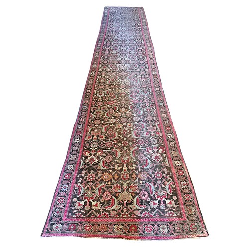 282 - A Persian Heriz handwoven long wool runner featuring geometric floral motifs throughout. The main fi... 