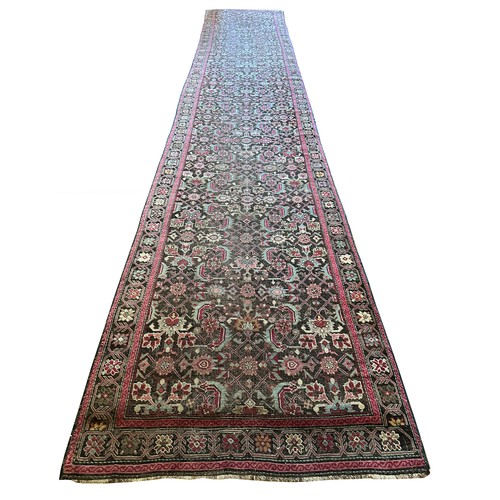 282 - A Persian Heriz handwoven long wool runner featuring geometric floral motifs throughout. The main fi... 