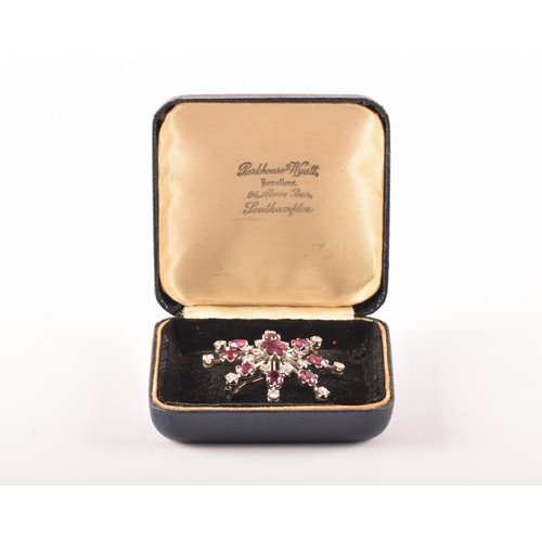 103 - An early 20th century white metal brooch featuring a oval old cut ruby to centre with an approximate... 