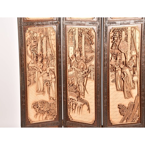 47 - A large Chinese carved wooden four fold dressing screen, elaborately carved with scenes of women in ... 