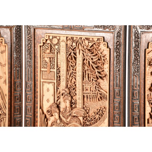 47 - A large Chinese carved wooden four fold dressing screen, elaborately carved with scenes of women in ... 