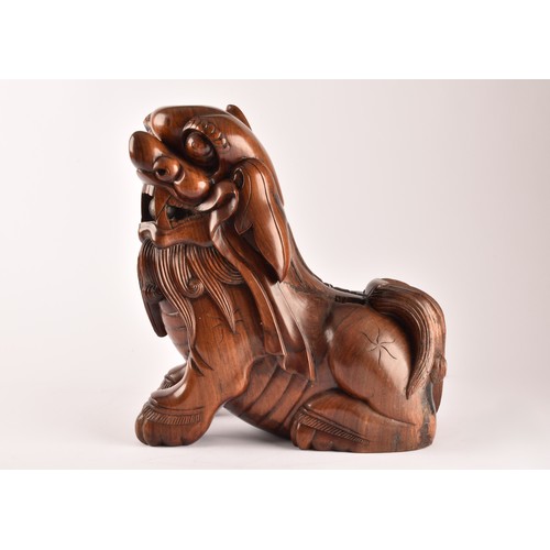 49 - A pair of early 20th century Chinese carved wooden dogs of foe, in a seated pose, with mouths agape.... 