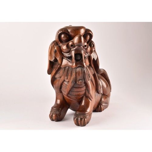 49 - A pair of early 20th century Chinese carved wooden dogs of foe, in a seated pose, with mouths agape.... 