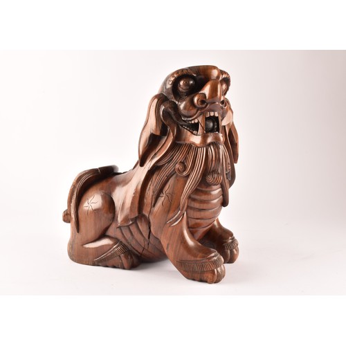 49 - A pair of early 20th century Chinese carved wooden dogs of foe, in a seated pose, with mouths agape.... 