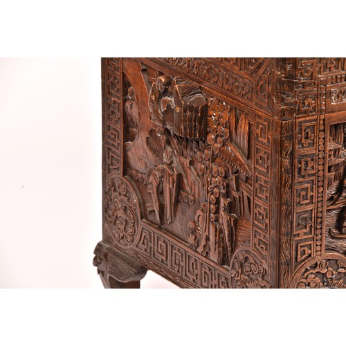 51 - A large Chinese carved camphor wood chest, elaborately carved all over with soldiers and horses trav... 