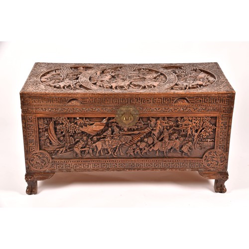 51 - A large Chinese carved camphor wood chest, elaborately carved all over with soldiers and horses trav... 