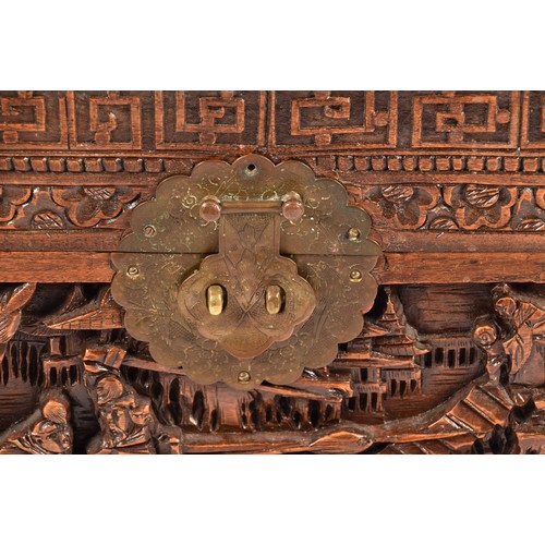 51 - A large Chinese carved camphor wood chest, elaborately carved all over with soldiers and horses trav... 