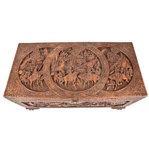 51 - A large Chinese carved camphor wood chest, elaborately carved all over with soldiers and horses trav... 