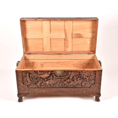 51 - A large Chinese carved camphor wood chest, elaborately carved all over with soldiers and horses trav... 