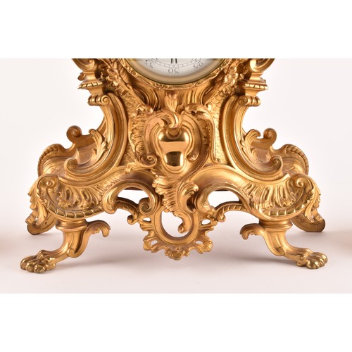 253 - An antique French gilt bronze Rococo style clock garniture, the mantel clock of waisted keyhole shap... 