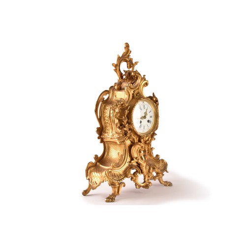 253 - An antique French gilt bronze Rococo style clock garniture, the mantel clock of waisted keyhole shap... 