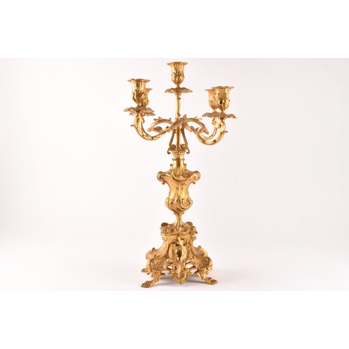 253 - An antique French gilt bronze Rococo style clock garniture, the mantel clock of waisted keyhole shap... 