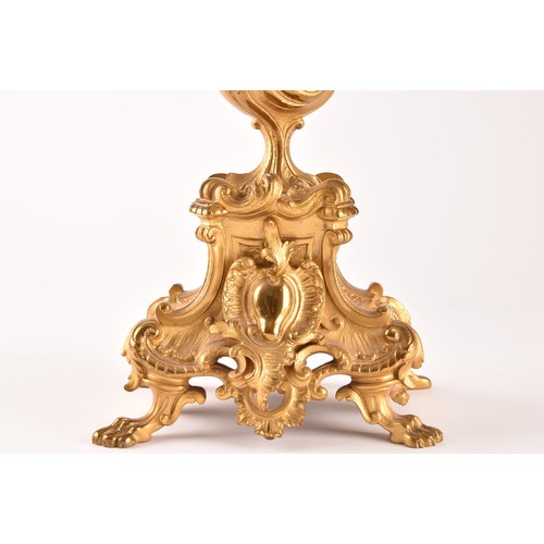 253 - An antique French gilt bronze Rococo style clock garniture, the mantel clock of waisted keyhole shap... 