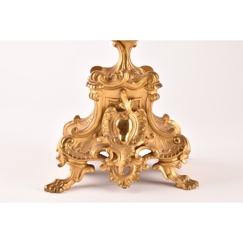 253 - An antique French gilt bronze Rococo style clock garniture, the mantel clock of waisted keyhole shap... 