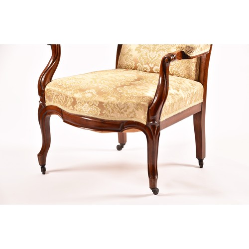 284 - A Victorian mahogany library spoonback armchair, with carved and scrolled open arms, show wood frame... 