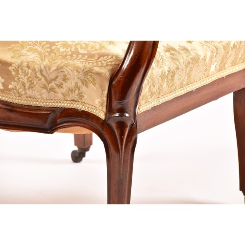 284 - A Victorian mahogany library spoonback armchair, with carved and scrolled open arms, show wood frame... 