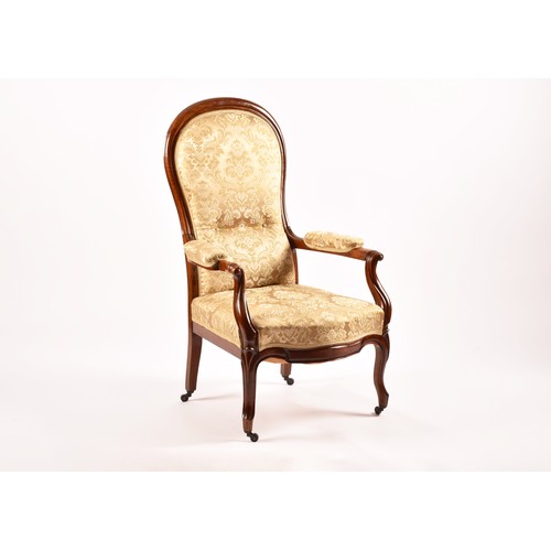 284 - A Victorian mahogany library spoonback armchair, with carved and scrolled open arms, show wood frame... 